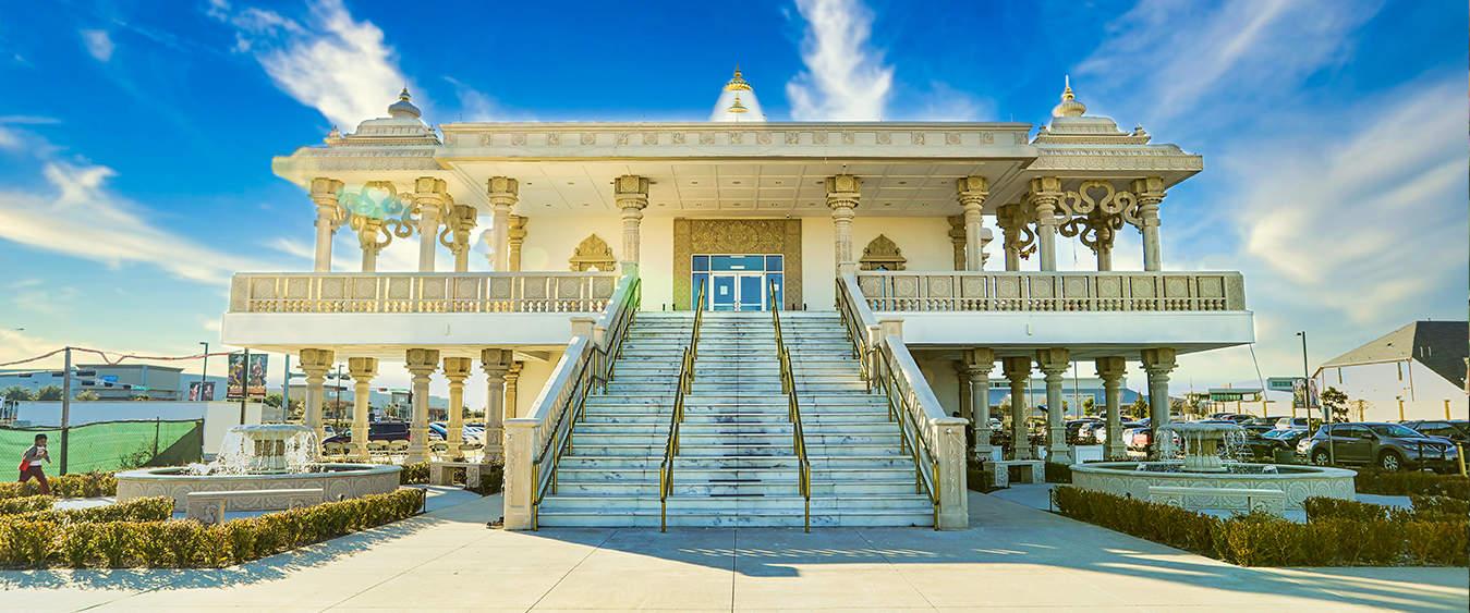 A huge Hindu temple building with stairs in front of it